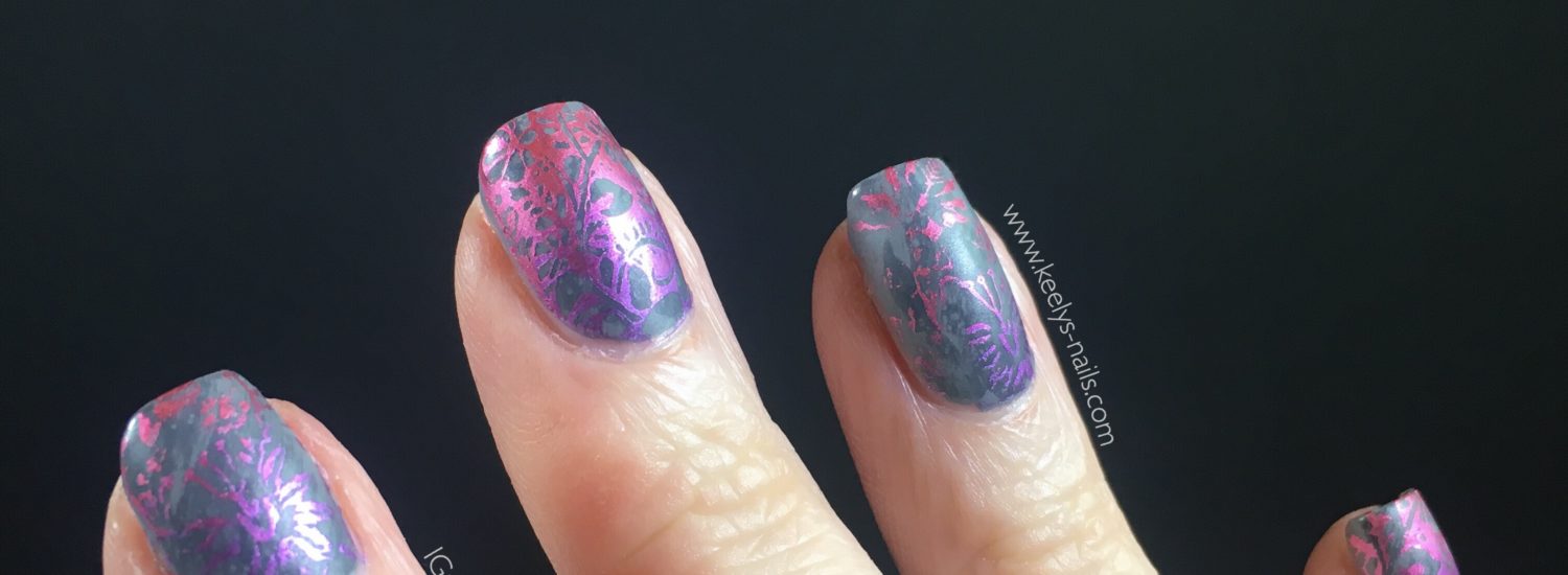 Right hand fingers on a black background with grey matte nails with a pink and purple gradient stamping design