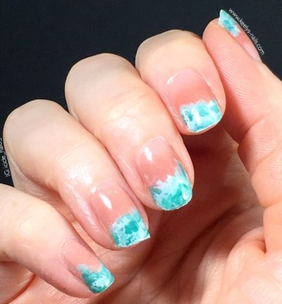 Right hand fingers curled gently into palm, on a black background. Nails with a pale pink gradient and a turquoise waves design at the tips.