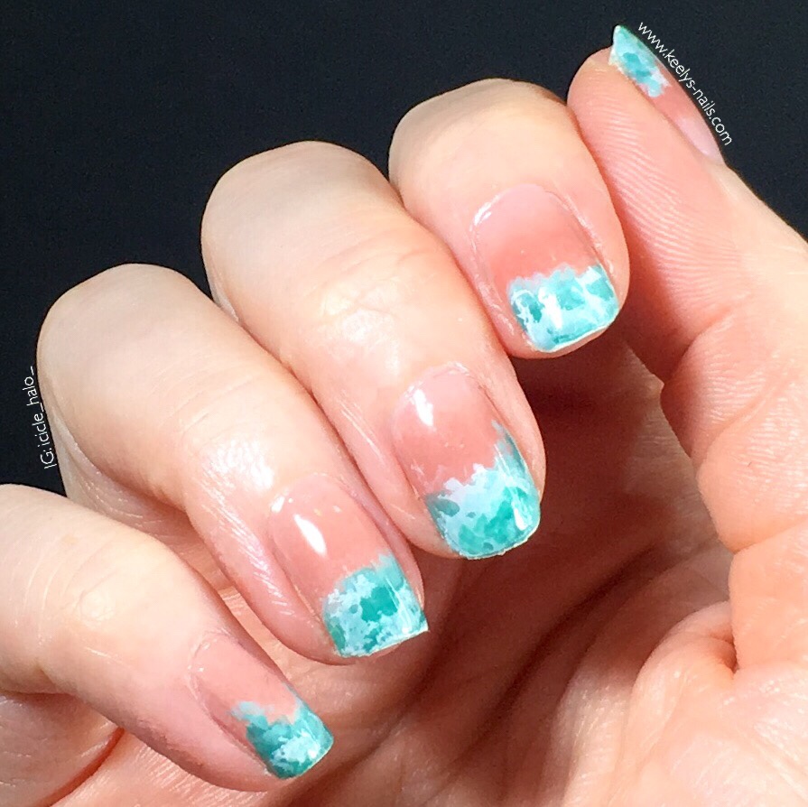 Right hand fingers curled gently into palm, on a black background. Nails with a pale pink gradient and a turquoise waves design at the tips.