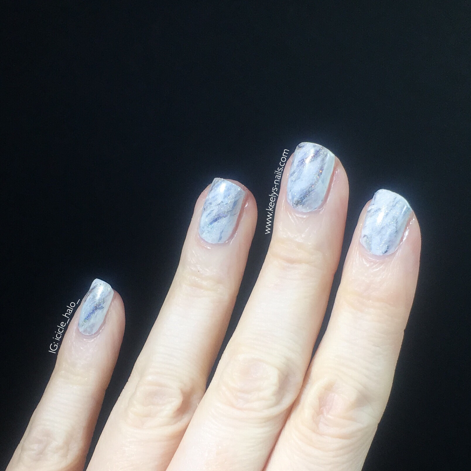 Left hand fingers with white marble nail art design