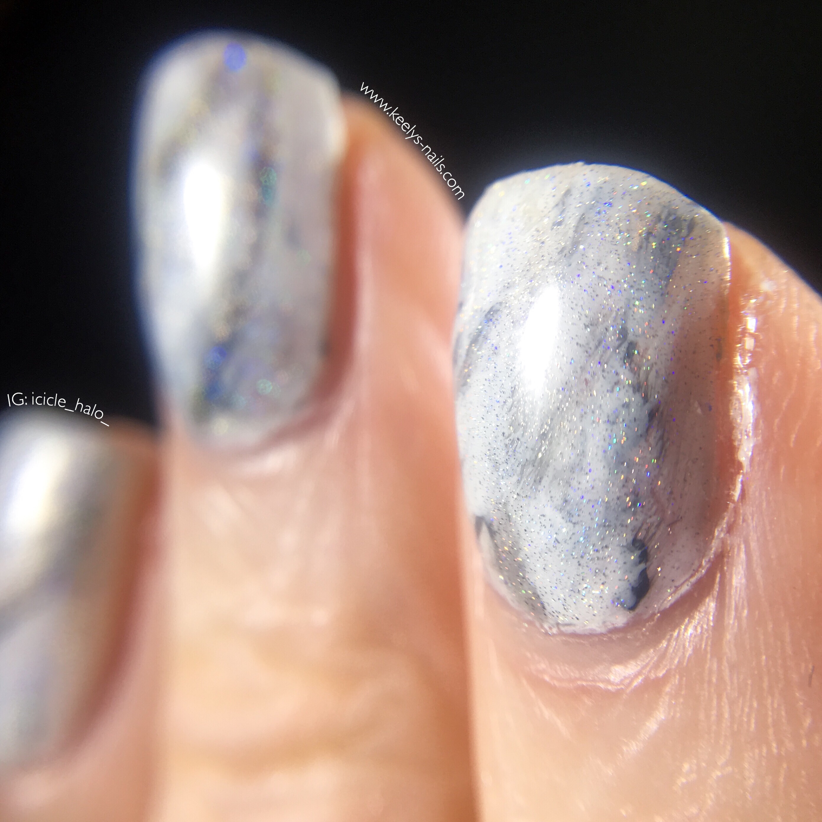 Close up of nail art on three left hand fingers with only the index finger in focus